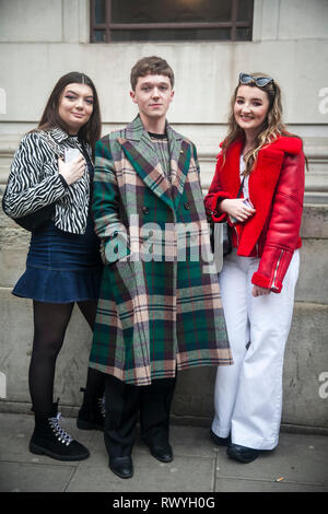 LONDON - 15. FEBRUAR 2019: Stilvolle Teilnehmer sammeln außerhalb 180 The Strand für die London Fashion Week. Ein Mann in einem Vintage grünen Mantel und Ausgestelltem Stockfoto