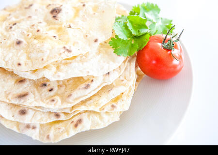 Pita Brot auf weißem Hintergrund mit einer Tomate Stockfoto