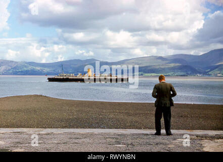 Junger Mann die Bilder Taille level Kamera historischen 1960 s 60 s Archivierung anzeigen Passagierschiff St Tudno in Menai Straits Landschaft vorbei an Beaumaris GROSSBRITANNIEN Stockfoto