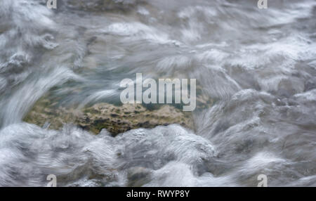 An der Küste der Ostsee einem Kalkstein in einem Meerwasser Swirl. Steiniger Strand von Saaremaa. Single Kalkstein im fließenden Wasser. Europa Estland Saaremaa. Stockfoto