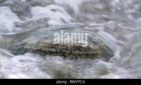 Eine einzelne Kalkstein in einem Meerwasser Strudel auf felsigen Ufer von Saarema. In Europa Estland. Whirlpool im Meerwasser. Ostsee. Stockfoto