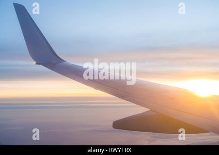 Himmel, Wolken bei Sonnenuntergang aus dem Fenster des Flugzeugs. Stockfoto