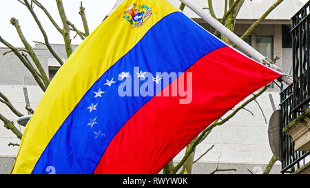 Eine venezolanische Fahne winken auf der Pole auf der Terrasse eines Gebäudes. Gezeigt wird die blattlosen Bäume auf der Straße Stockfoto