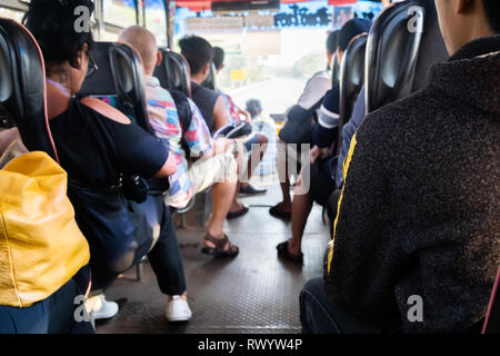Leute sitzen auf dem Sitz in der Rückansicht auf dem Bus. Stockfoto