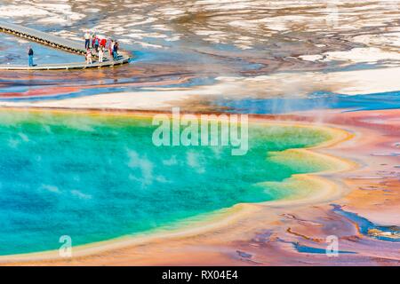 Touristen auf einem Steg im thermischen Bereich, dampfende heiße Quelle, Grand Prismatic Spring, Midway Geyser Basin Stockfoto