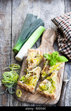 Tarte mit Speck und Käse Stücke auf hölzernen Tisch Stockfoto