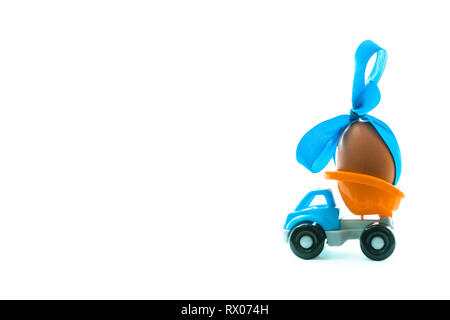 Ostereier und Spielzeugauto auf weißem Hintergrund, frohe Ostern tag Konzept, Platz für Text Stockfoto