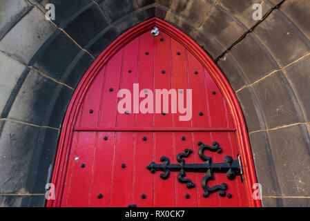 Blick auf den Eingang und das rote Portal der St Columba's Free Church of Scotland auf der Royal Mile, Edinburgh, Schottland. Stockfoto