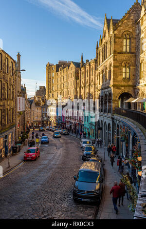 Edinburgh, Schottland - Dez 2018. Blick auf die bunten Gebäude und Geschäfte im Westen Bogen, Victoria Street in einem warmen orange Sonnenuntergang. Stockfoto