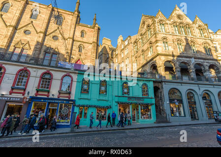 Edinburgh, Schottland - Dez 2018. Blick auf die bunten Gebäude und Geschäfte im Westen Bogen, Victoria Street in einem warmen orange Sonnenuntergang. Stockfoto