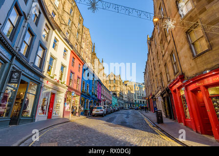 Edinburgh, Schottland - Dez 2018. Blick auf die bunten Gebäude und Geschäfte im Westen Bogen, Victoria Street in einem warmen orange Sonnenuntergang. Stockfoto
