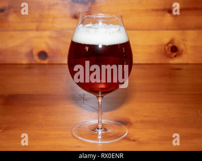 Erfrischend, Amber Ale oder Bier in einer Tulpe Glas auf einem Holz Hintergrund Stockfoto