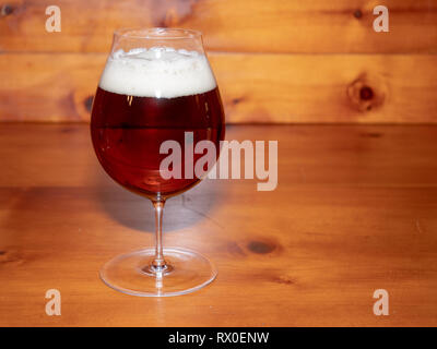 Erfrischend, Amber Ale oder Bier in einer Tulpe Glas auf einem Holz Hintergrund Stockfoto