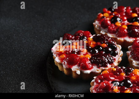 Törtchen mit Beeren nahe bis auf dunklen zurück Stockfoto