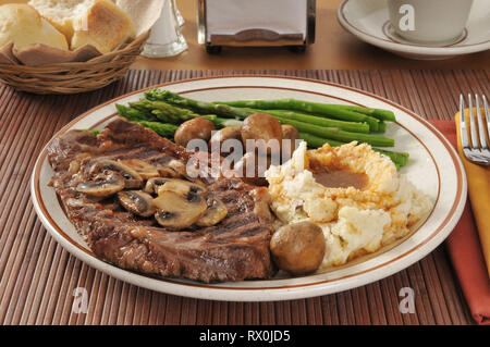 Ein Gegrilltes Rib Steak mit sautierten Pilzen, Spargel, und Kartoffelpüree Stockfoto
