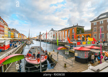 Touristen besichtigen, board Angelboote Speisen und Straßencafés an einem Herbsttag auf das 17. Jahrhundert waterfront canal Nyhavn in Kopenhagen, Dänemark. Stockfoto