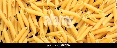 Italienisches Essen. Ungekocht trocken Penne Rigate Form pasta Textur Hintergrund, Banner Stockfoto