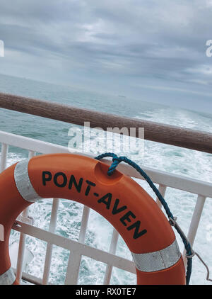 Rettungsring mit Rettungsring an Geländern auf der Fähre Pont-Aven Bretagne. Blick über das Geländer des Horizonts, das Gefolge der Fähre, das Meer. Segeln von England nach Spanien. Stockfoto