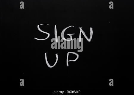 Anmelden weiße Kreide auf eine schwarze Kreide Bord geschrieben Stockfoto