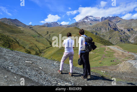 Kazbegi, Georgien - May 24, 2018. Glückliches Paar Wandern in den Bergen der Kazbegi, Georgia. Mount Kazbegi liegt an den nördlichen Hängen des Kaukasus gelegen Stockfoto