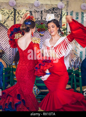 Junge und schöne Frauen mit Flamenco Kleider und Tanzendes evillanas' an der Feria de Abril in Sevilla Messe (Feria de Sevilla) Stockfoto