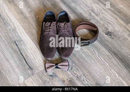 Zubehör für den Bräutigam Schuhe, Gürtel, Manschettenknöpfe und ein Schmetterling. Stockfoto