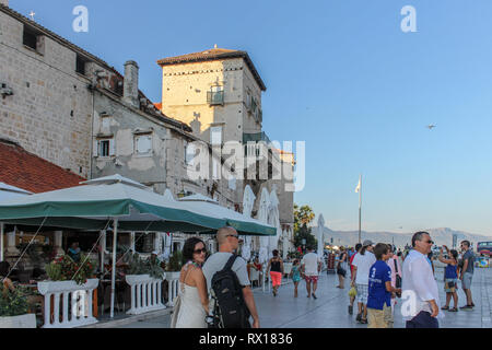 Trogir Promenade & Mala Loza (Loggia/Galerie) voll mit Touristen. Ein Flugzeug ist vom Flughafen Split im Hintergrund Stockfoto