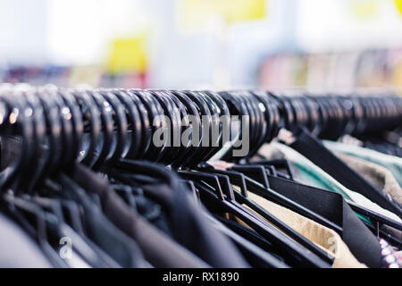 Kleider auf Kleiderbügeln im Shop. Close Up. Stockfoto