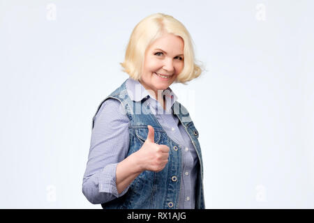 Lächelnd schöne ältere Frau, Daumen nach oben. Positiven menschlichen Gesichts emotion Stockfoto