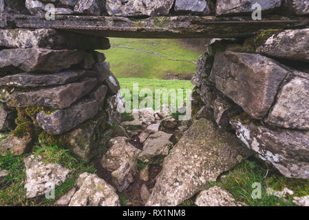 Eine Ansicht des Peak District durch ein Loch in eine Wand aus Felsen und Steine in Großbritannien hergestellt Stockfoto