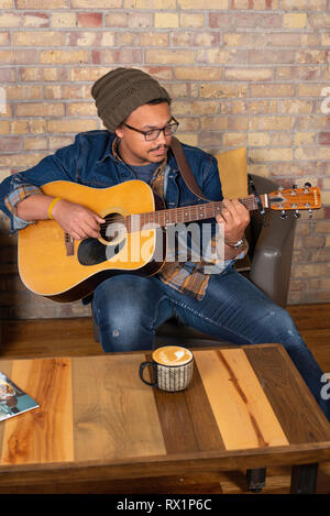 Mann mit Gitarre im Café in der Innenstadt Twin Falls, Idaho. Stockfoto