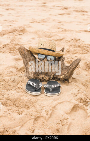 Hohe Betrachtungswinkel der Sonne hut mit Flip-flops und Sonnenbrille auf Holz am Strand arrangiert Stockfoto