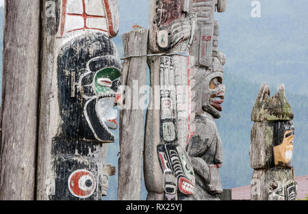 Verwitterte Totempfähle stehen mit Blick auf das Meer an der Namgis Grabstätte auf Kormoran Insel. Alert Bay, British Columbia, Kanada. Stockfoto