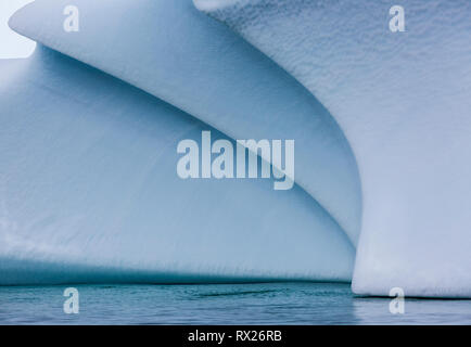 Ein geerdeter Eisberg zeigt wunderschöne weiche geschwungene Linien, während er sich langsam im flachen Wasser in der Nähe von Pleneau Island verschlechtert. Antarktische Halbinsel, Antarktis. Stockfoto