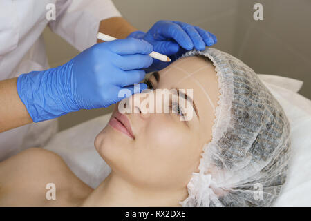 Ästhetische Kosmetologie. Facelift in Spa Salon. Kosmetikerin macht Markup für die Injektion. Glättung von Falten nachahmen. Stockfoto