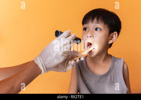 Close up Arzt Prüfung der Kehle des Patienten mit zungenspatel. Stockfoto