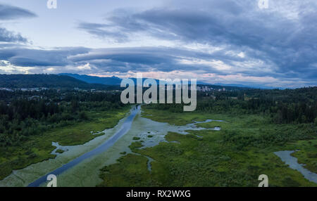 Antenne Panoramablick von Burnaby Lake in einer dramatischen trübe Sommer Sonnenuntergang. In Vancouver, British Columbia, Kanada. Stockfoto