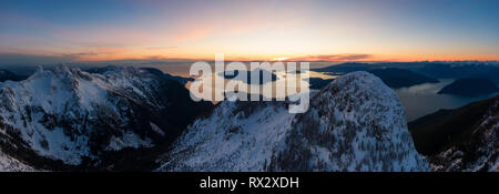 Antenne Panoramablick auf Howe Sound Bergen während einer lebhaften winter Sonnenuntergang. In der Nähe von Löwen Bucht, nördlich von Vancouver, BC, Kanada. Stockfoto