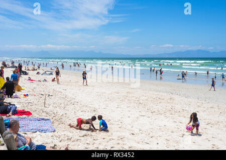 Einem langen Strand Tag mit Massen von strandgängern Spaß an einem heißen Tag Sommer in Muizenberg, False Bay, Cape Peninsula, Cape Town, Südafrika Stockfoto