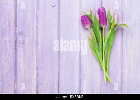 Lila Tulpen Strauß auf Holztisch. Ansicht von oben mit Platz für Ihren Text Stockfoto