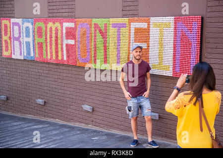 Johannesburg, Südafrika, 24. Februar 2019: Mann posieren für ein selfie weiter auf Wand zu unterzeichnen Stockfoto