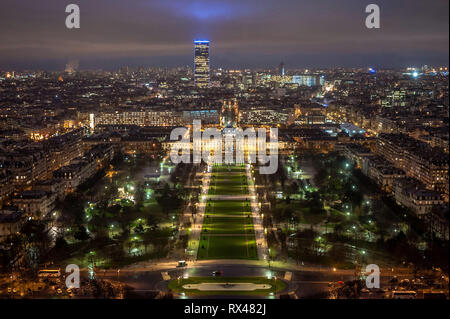 Paris (Frankreich): Champ-de-Mars, großen öffentlichen Raum vom Eiffelturm bei Anbruch der Dunkelheit gesehen. Die ÒTour MontparnasseÓ Hochhaus im Hintergrund. Stockfoto