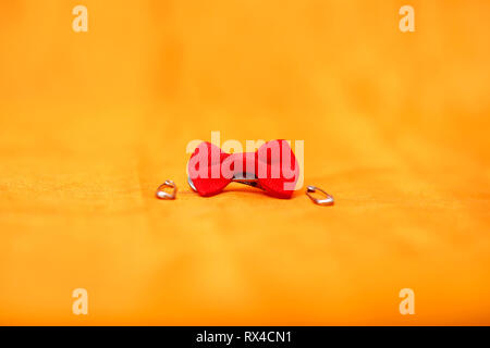 Bild von Safety Pin und roter Schleife. Auf den gelben Hintergrund. Stockfoto