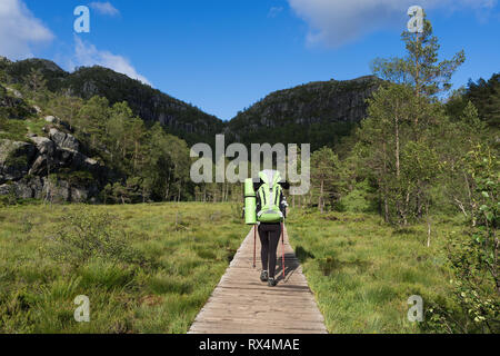 Touristen mit einem Rucksack auf Weg Preikestolen, Norwegen. Girl in a Mountain Trek Stockfoto