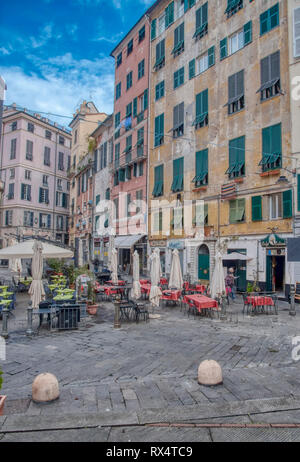 Restaurant in Piazza delle Erbe mit hohen bunten historischen Stadthäusern mit Blick auf den Platz in Genua, Italien Stockfoto