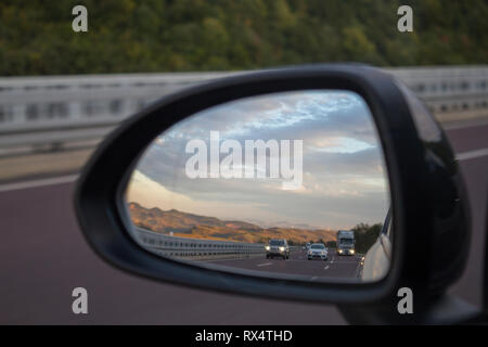 Autobahn aus dem Auto Rückspiegel Stockfoto