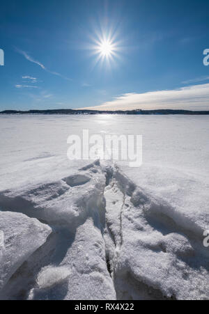 Malerische Winterlandschaft mit hellem Sonnenlicht und Sonne im Winter Tag in See Finnland Stockfoto