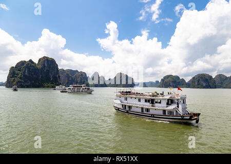 Kreuzfahrt Boote segeln unter die Karsterscheinungen in der Halong Bay, Vietnam, im Golf von Tonkin. Halong Bay ist ein UNESCO-Weltkulturerbe und die Stockfoto