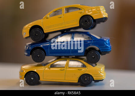 Drei Spielzeugautos in Gelb und Blau innen bei einem preeschool in Schweden Stockfoto