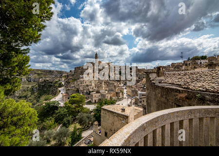 MATERA, Italien - 27. AUGUST 2018: Sommer Tag Landschaft Straße Blick auf die herrliche alte Stadt der Sassi mit weißen geschwollene Wolken ziehen auf dem Italienischen Stockfoto